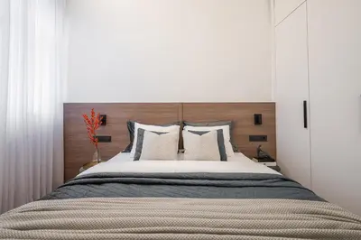 a bedroom with a large bed with a wooden headboard at Modern Apartment in the heart of Vilnius Old Town with free parking by URBAN RENT in Vilnius