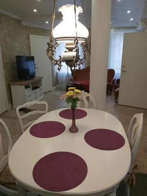 a white table with a vase of flowers on it at HOMESTAY ,,Aurora,, in Vilnius