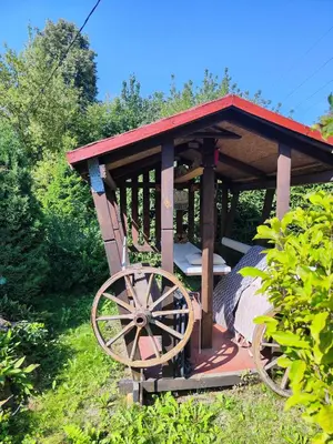 a wooden gazebo with a bed in it at HOMESTAY ,,Aurora,, in Vilnius