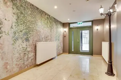 an empty hallway with a wall with flowers at Sunrise Uzupis Apartment in Vilnius