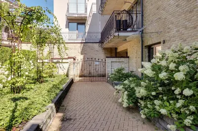 a brick walkway in front of a building with flowers at Sunrise Uzupis Apartment in Vilnius