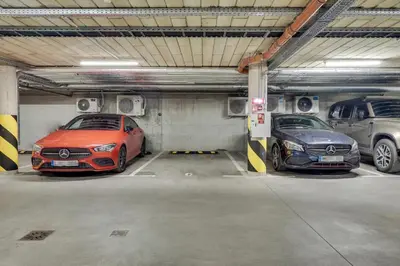two cars are parked in a parking garage at Sunrise Uzupis Apartment in Vilnius