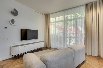 a living room with a couch and a flat screen tv at Sunrise Uzupis Apartment in Vilnius