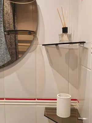 a mirror on a wall next to a table at Mocha Apartment in Druskininkai