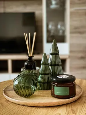 a wooden plate with a jar of honey and christmas trees at Mocha Apartment in Druskininkai