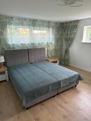 a bedroom with a bed with a blue comforter at Gilės namai in Kaunas