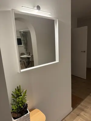a mirror on a wall in a living room at Gilės namai in Kaunas