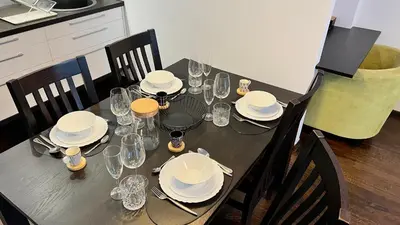 a dining table with plates and glasses on it at Zygio Apartamentai in Vilnius