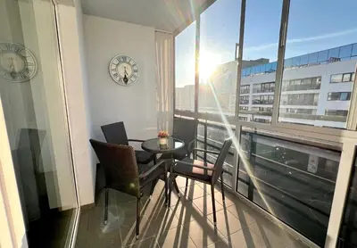 a balcony with a table and chairs and a clock at Zygio Apartamentai in Vilnius