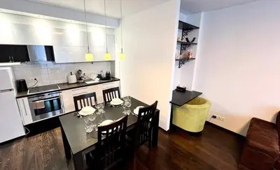 a kitchen with a table and chairs in a room at Zygio Apartamentai in Vilnius