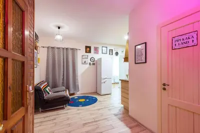 a living room with a pink door and a chair at Vilnius Pinewood Apartment in Vilnius
