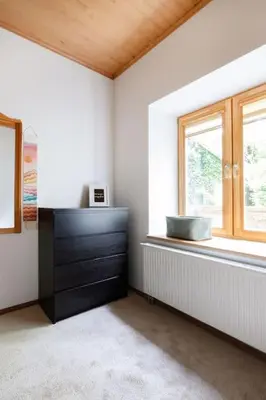a room with a dresser and a window at Vilnius Pinewood Apartment in Vilnius