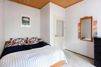 a white bedroom with a bed and a mirror at Vilnius Pinewood Apartment in Vilnius