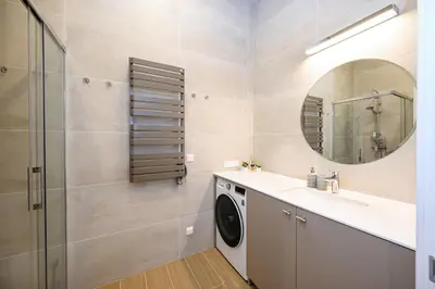 a bathroom with a sink and a washing machine at 2BD NEW Apt w-Balcony I Parking inc I next to the River and Forest I by Cohost in Birštonas