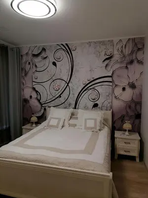 a bedroom with a bed with a flowery wall at Privatus 2kambariu butas in Birštonas