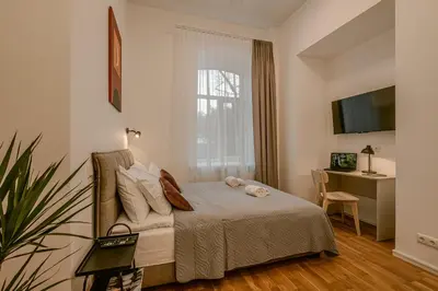 a bedroom with a bed and a desk and a window at Railway Apartments in Vilnius
