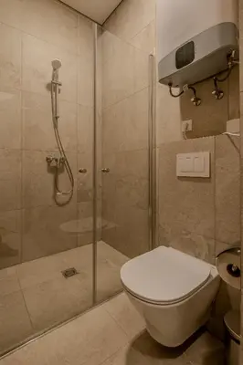 a bathroom with a shower with a toilet and a glass shower stall at Railway Apartments in Vilnius