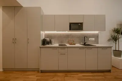 a kitchen with white cabinets and a sink at Railway Apartments in Vilnius