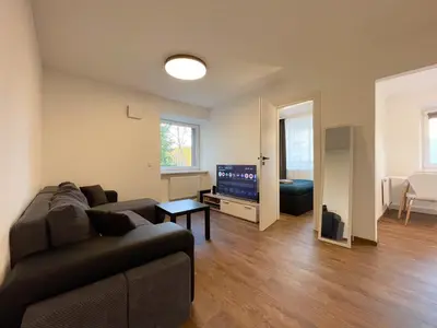 a living room with a couch and a tv at IG Apartments in Karmėlava