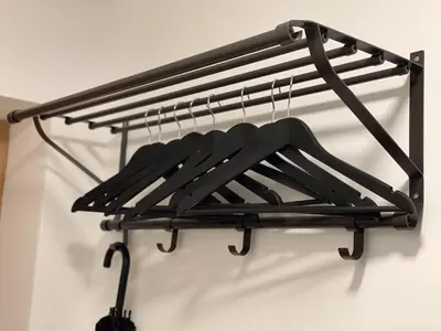 a black coat rack hanging on a wall at IG Apartments in Karmėlava