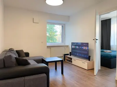 a living room with a couch and a flat screen tv at IG Apartments in Karmėlava