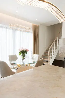 a dining room with a table and chairs and a staircase at Luxury villa with sauna in the pine forest close to Vilnius city centre in Vilnius