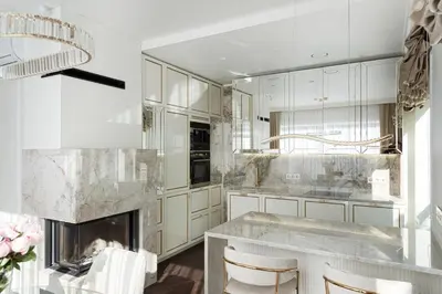 a kitchen with white cabinets and a fireplace at Luxury villa with sauna in the pine forest close to Vilnius city centre in Vilnius