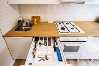 a kitchen counter with a sink and a stove at Thibo Apartamentas in Šiauliai