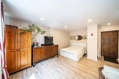 a bedroom with a bed and a dresser with a television at Thibo Apartamentas in Šiauliai