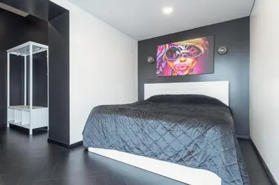 a bedroom with a bed with a tv on the wall at Top Loft Kaunas in Kaunas