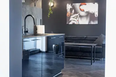 a kitchen and living room with a black couch at Top Loft Kaunas in Kaunas