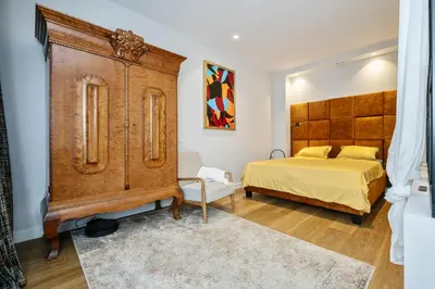 a bedroom with a bed and a large wooden cabinet at Old Town Luxury Apartments in Vilnius