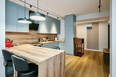 a kitchen with a wooden table and blue cabinets at Old Town Luxury Apartments in Vilnius