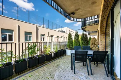 a patio with a table and chairs and potted plants at Old Town Luxury Apartments in Vilnius