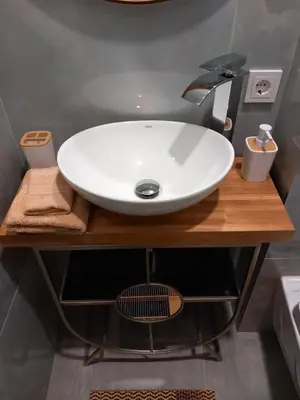 a bathroom with a white sink on a wooden counter at SPA TOWN house II in Druskininkai