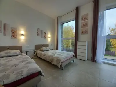 a bedroom with two beds and a large window at SPA TOWN house II in Druskininkai
