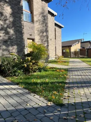 a sidewalk in front of a brick building with grass at SPA TOWN house II in Druskininkai
