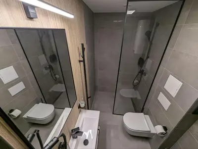 a bathroom with two toilets and a shower and a sink at Durpyno 3c SELF CHECK-IN in Panevėžys