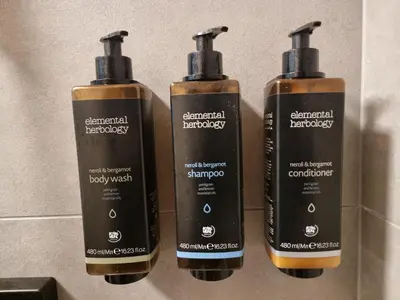 a group of three shampoo bottles on a wall at Durpyno 3c SELF CHECK-IN in Panevėžys