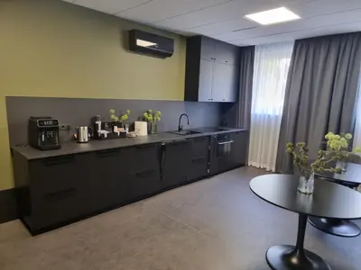 a kitchen with black cabinets and a table in a room at Durpyno 3c SELF CHECK-IN in Panevėžys