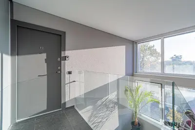 a glass door in a hallway with a potted plant at Oak Park Apartment in Kaunas