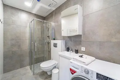 a bathroom with a toilet and a sink and a shower at Oak Park Apartment in Kaunas