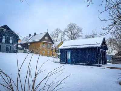 a snow covered yard with a building and a house at Lakeview Modern Karaim Cottage Trakai in Trakai