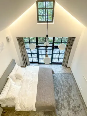 a bedroom with a large bed and a large window at Lakeview Modern Karaim Cottage Trakai in Trakai