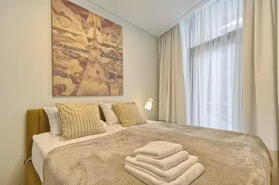 a bedroom with a large bed with towels on it at Drusk Sun in Druskininkai