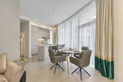 a dining room with a table and chairs and a kitchen at Drusk Sun in Druskininkai