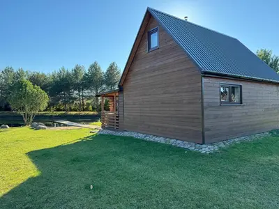 a small cabin with a gambrel roof on a lawn at Pinetree House in Gudeliai