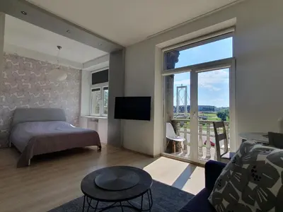 a living room with a bed and a large window at Kaunas Center Apartments - K. Mindaugo g. in Kaunas