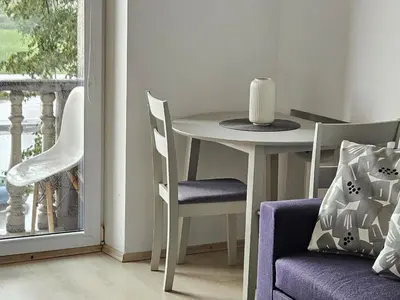 a table and chairs in a room with a window at Kaunas Center Apartments - K. Mindaugo g. in Kaunas