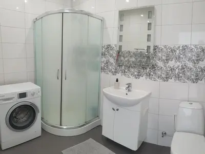 a bathroom with a sink and a washing machine at Kaunas Center Apartments - K. Mindaugo g. in Kaunas